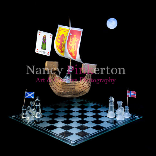 Photographic art print with image of a playing card featuring Margaret the Maid of Norway and a sail boat floating above a chessboard arranged with two groups of chess pieces one with a Scottish flag and the other with a Norwegian flag.