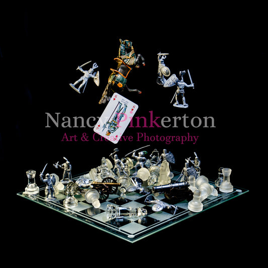 Photographic art print with image of a playing card featuring King James III falling from a horse next to 3 solider figures all floating above a glass chessboard with a chaotic arrangement of chess pieces, solider figures and miniature cannons.