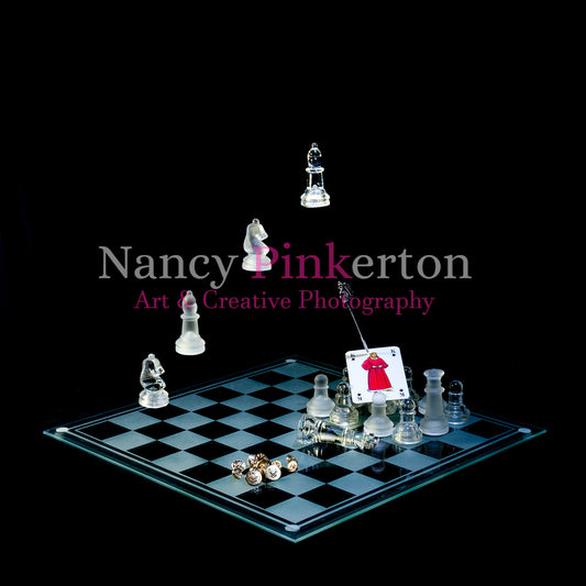 Photographic art print with image of a playing card featuring King James I emerging from a group of chess pieces on a glass chessboard a sword floating above with tip on card. In background four chess pieces float above in the formation of stairs.