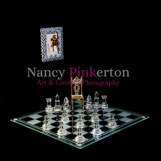 Photographic art print with image of a playing card featuring King Robert III reflected in a mirror floating above a glass chessboard with chess pieces strategically placed around an empty throne.